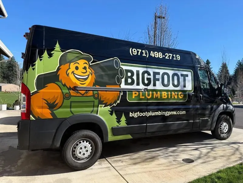 Side view of Bigfoot Plumbing wrapped service van in a Sandy, Oregon driveway, licensed plumber CCB# 257405 serving Sandy, Boring & Gresham OR