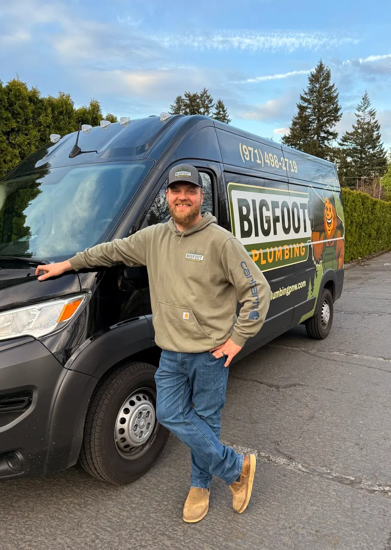 Kevin Brain, owner of Bigfoot Plumbing, standing next to his branded service van in Sandy, Oregon, family-owned local plumber serving Sandy, Boring, and Gresham OR