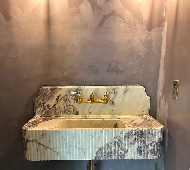 Custom marble vanity sink with brass wall-mounted faucet installed by Bigfoot Plumbing in Gresham, Oregon, fixture installation by licensed plumber CCB# 257405
